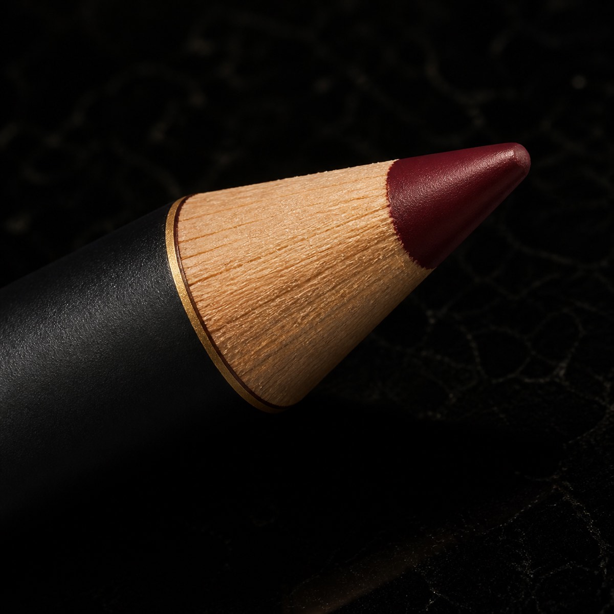 Lip Liner — the working end at magnification — under a single warm gold light on black.