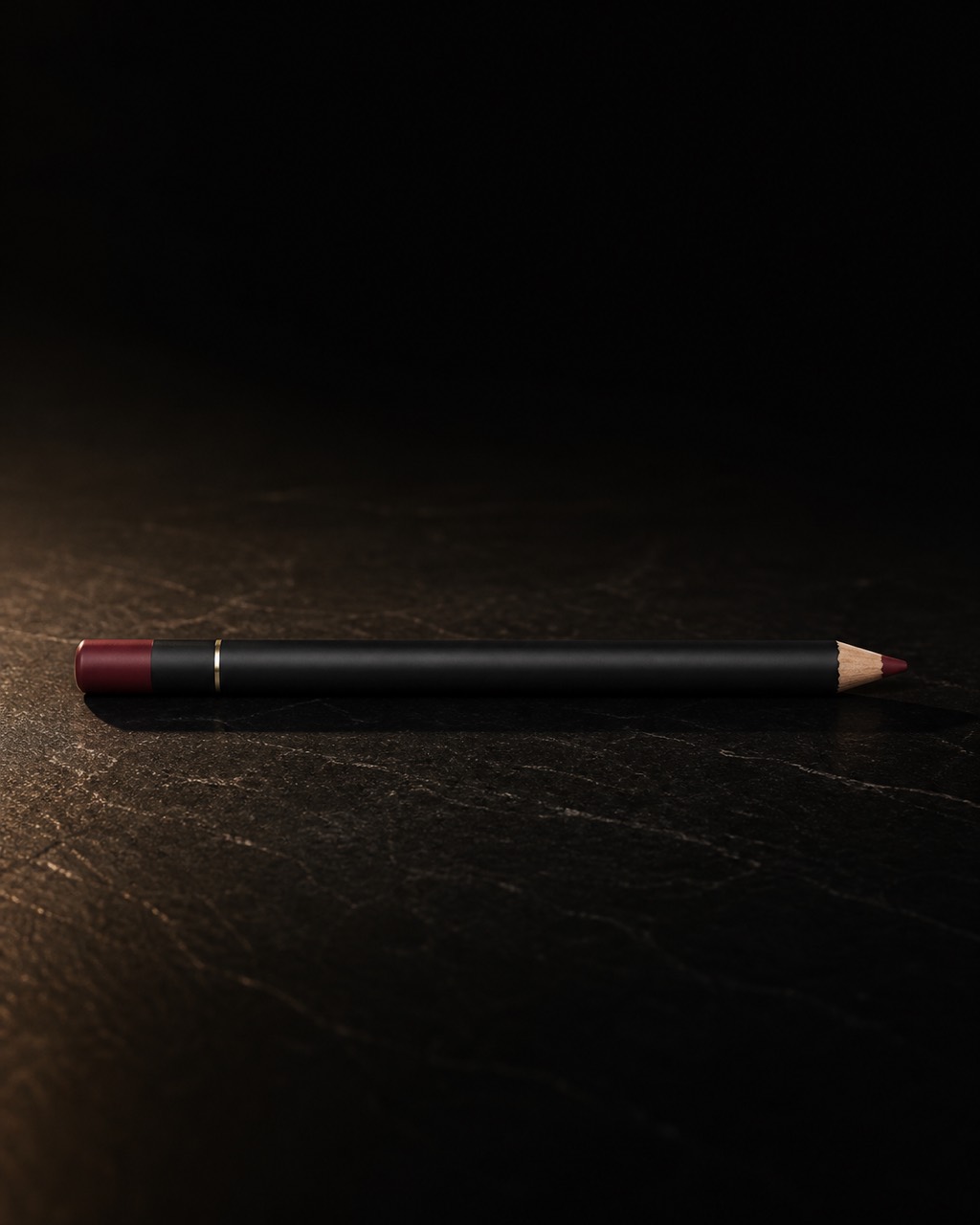 Lip Liner — daily lip liner — standing alone against near-black under a single warm gold light.