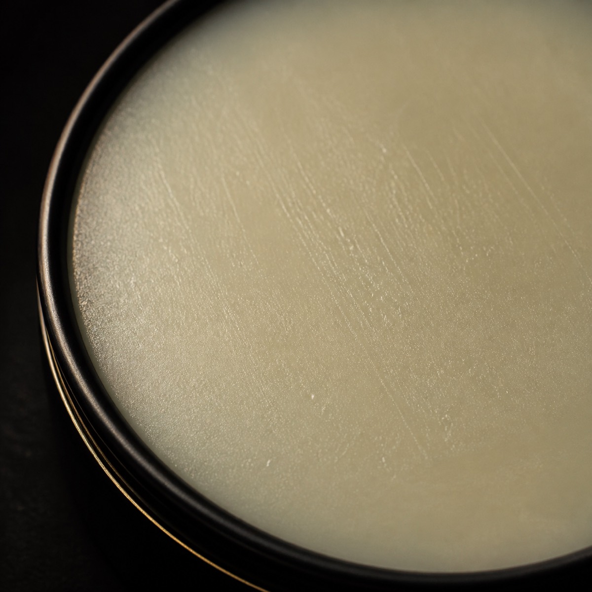 Solid Fragrance — the working end at magnification — under a single warm gold light on black.