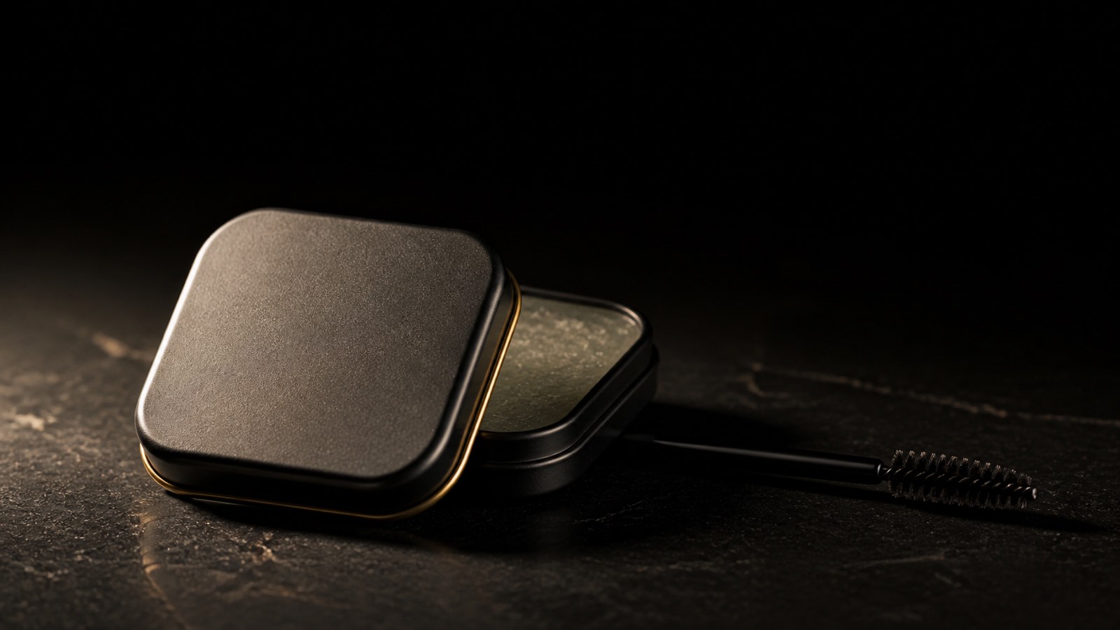 Brow Soap — seen in three-quarter view, low in a wide frame — under a single warm gold light on black.