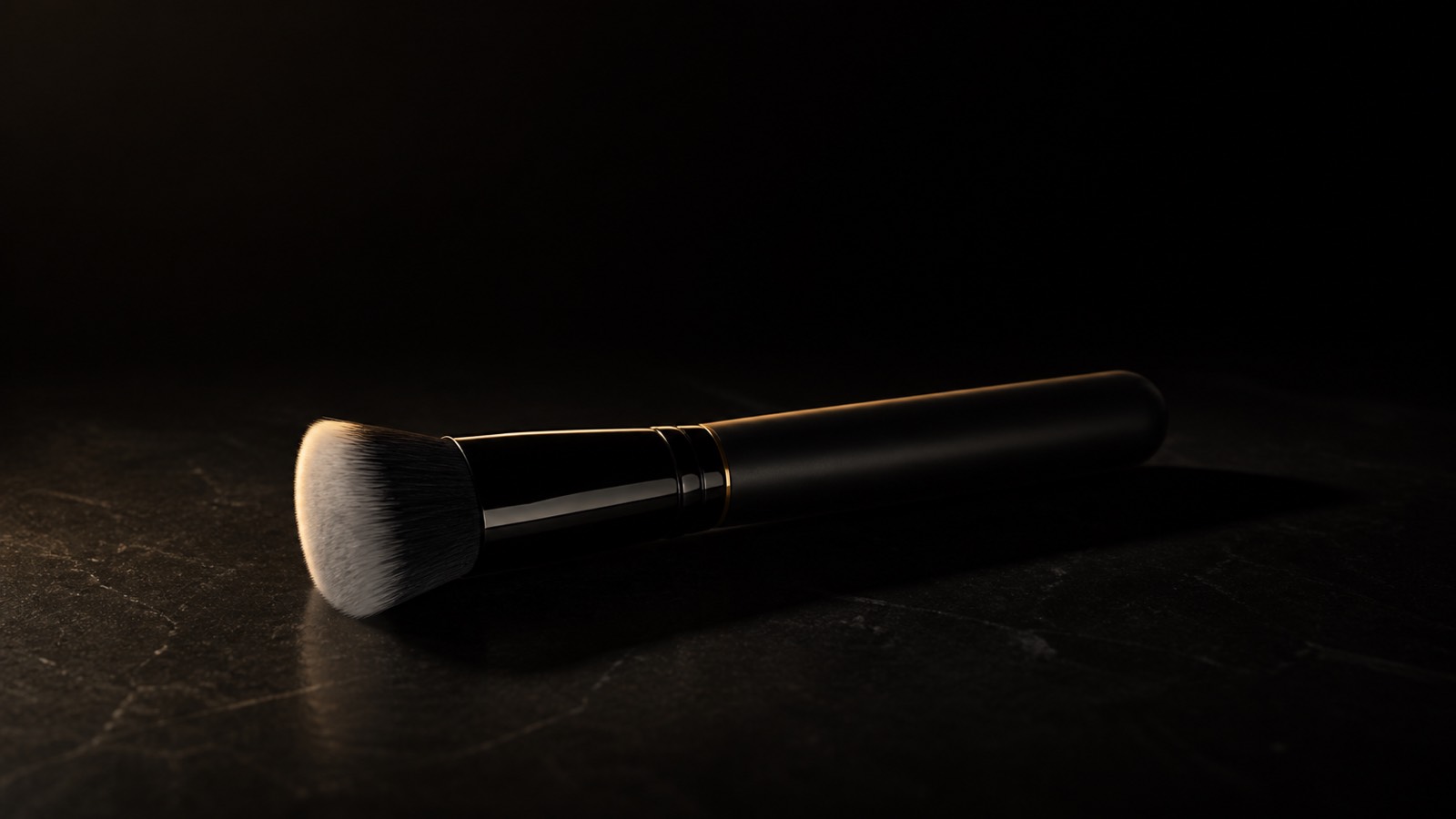 Stipple & Blend Brush — seen in three-quarter view, low in a wide frame — under a single warm gold light on black.