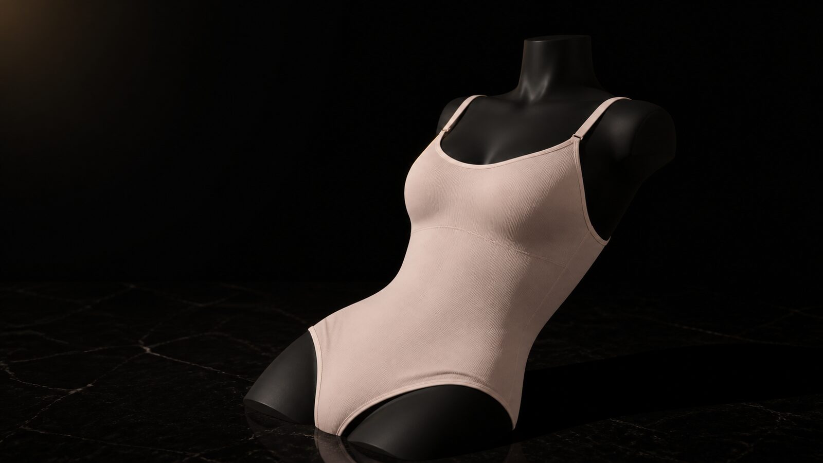 Scoop-Neck Shaping Bodysuit — seen in three-quarter view, low in a wide frame — under a single warm gold light on black.