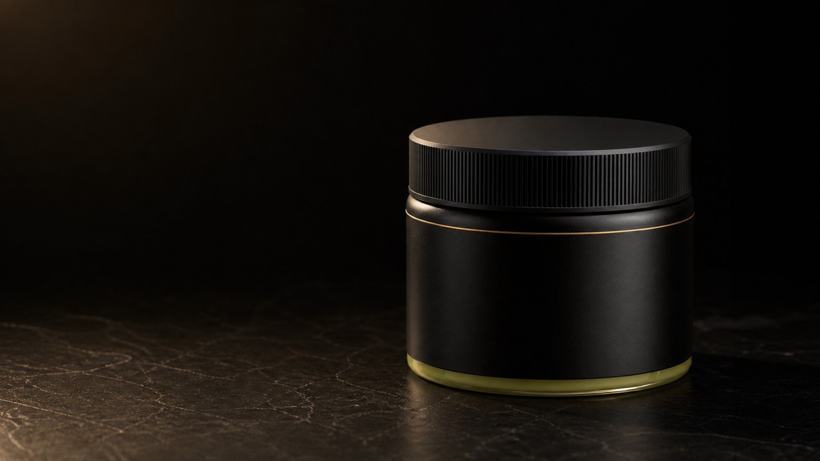 Raw Shea Butter — seen in three-quarter view, low in a wide frame — under a single warm gold light on black.