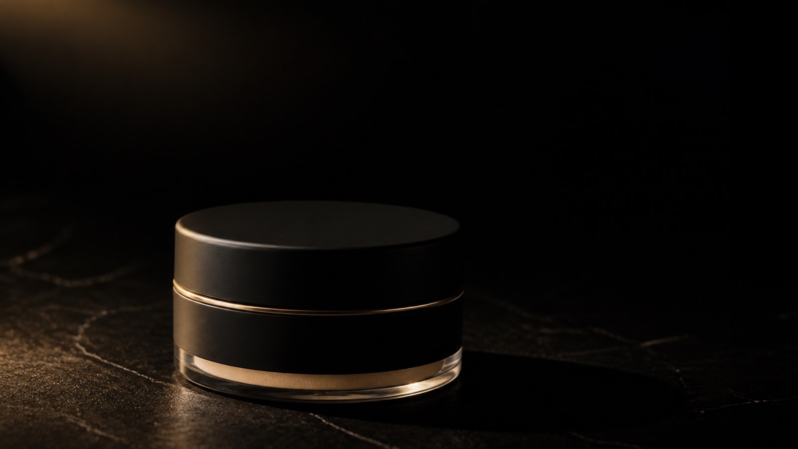 Loose Powder — Banana — seen in three-quarter view, low in a wide frame — under a single warm gold light on black.