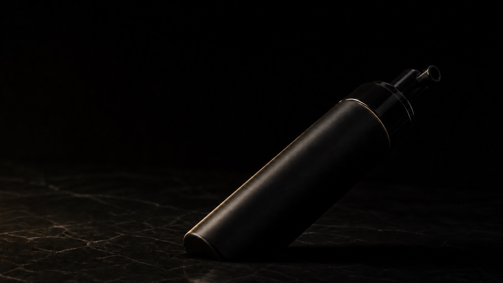 Foaming Cleanser — seen in three-quarter view, low in a wide frame — under a single warm gold light on black.