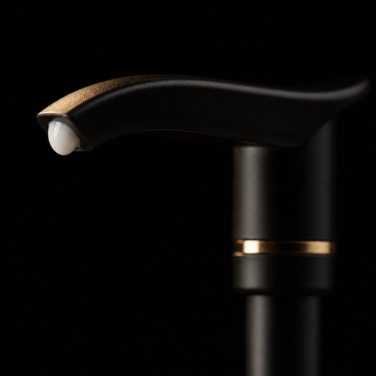 Hand & Body Moisturizer — the working end at magnification — under a single warm gold light on black.