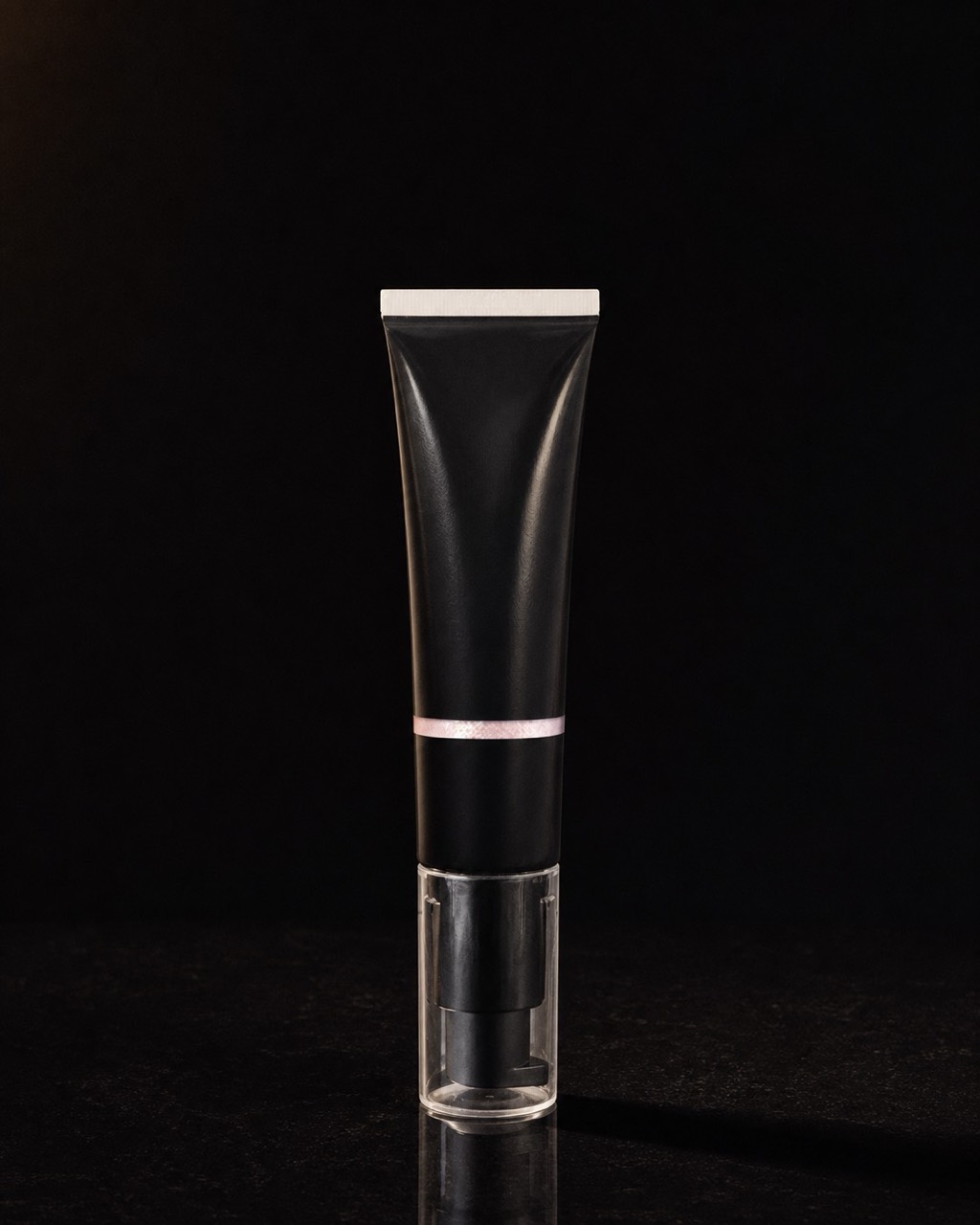 Illuminator — body and face luminizer — standing alone against near-black under a single warm gold light.