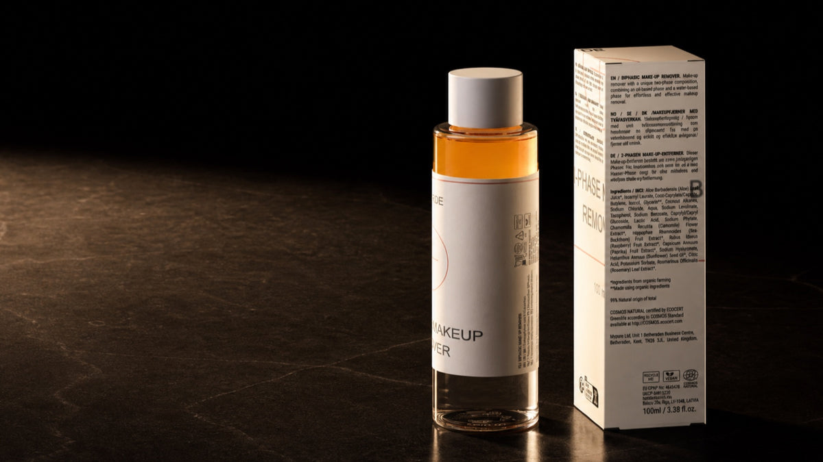 Bi-Phase Makeup Remover. The bottle laid across the wide frame, seen side on.