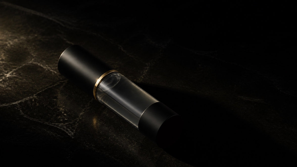 Perfect Canvas Primer — seen in three-quarter view, low in a wide frame — under a single warm gold light on black.